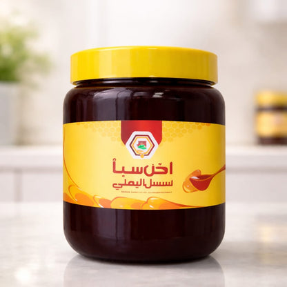 Jar of honey with a yellow label on a reflective surface